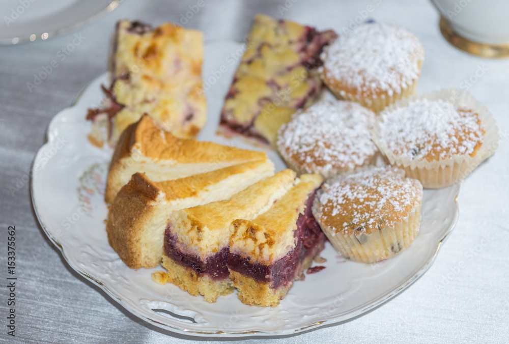 Kuchenplatte mit Stücken von Käsekuchen, Muffins, Zwetschenkuchen und Kirschkuchen Kuchenplatte mit Stücken von Käsekuchen, Muffins, Zwetschenkuchen und Kirschkuchen