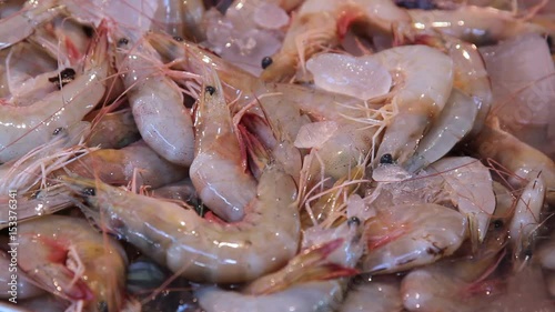 Fresh raw yellow prawns on ice are sold in the local market close up
