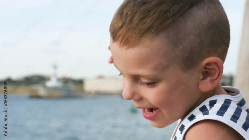 funny little boy in sailor stripes shirt on sky and sea background funny little boy in sailor stripes shirt on sky and sea background
