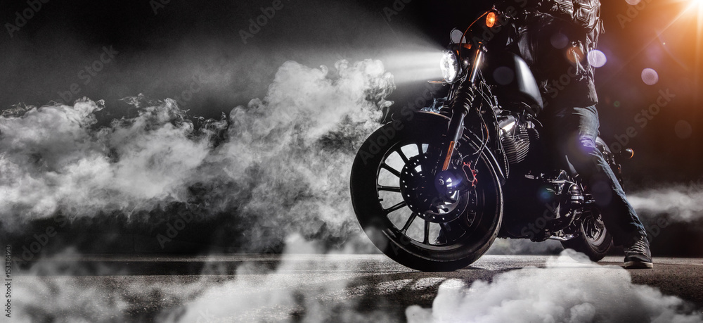 Naklejka premium Close-up z siekacza motocyklowego wysokiej mocy z jeźdźca człowieka w nocy