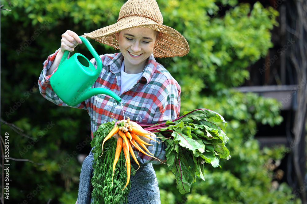 Wiosenne warzywa. Kobieta myje warzywa zebrane w ogródku - obrazy, fototapety, plakaty 