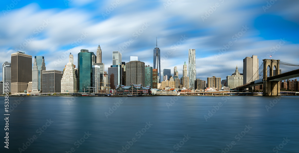 Naklejka premium Manhattan skyline and Brooklyn Bridge with waves ot the Hudson river