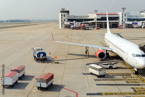 Aircraft worker receiving fuel to the airplane