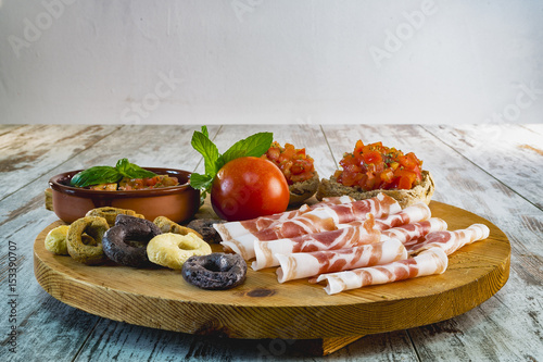 tagliere pancetta friselle pugliesi condite con pomodori e taralli a tre gusti dal basso