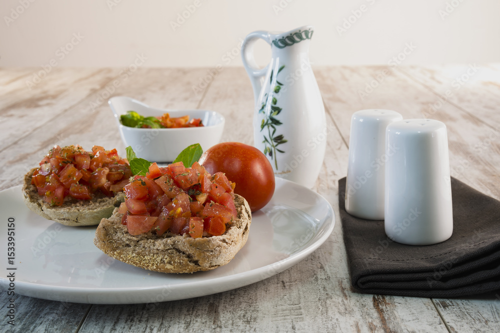 friselle pugliesi condite con olio sale pomodoro fresco e origano dal basso con oliera friselle pugliesi condite con olio sale pomodoro fresco e origano dal basso con oliera