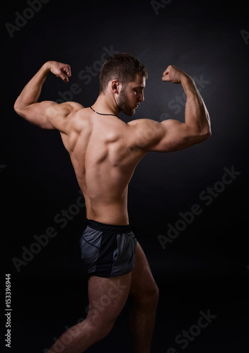 Young bodybuilder on a black background