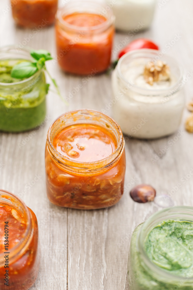 selection of sauces inside jar over wooden table selection of sauces inside jar over wooden table