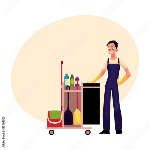 Boy, man, cleaner in overalls with cleaning trolley, cartoon vector illustration with space for text. Full length portrait of young man, boy with professional cleaning trolley