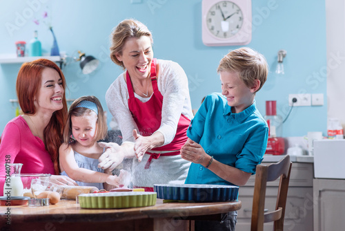 A family of four making pastry in a full color kitchen