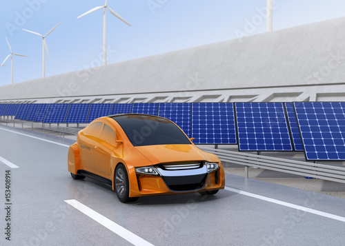 Electric car driving on the wireless charging lane of the highway. Solar panel station and wind turbine on the roadside. 3D rendering image.