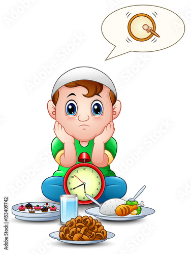 Muslim kid sit on the floor while wait break fasting with some food in front of him