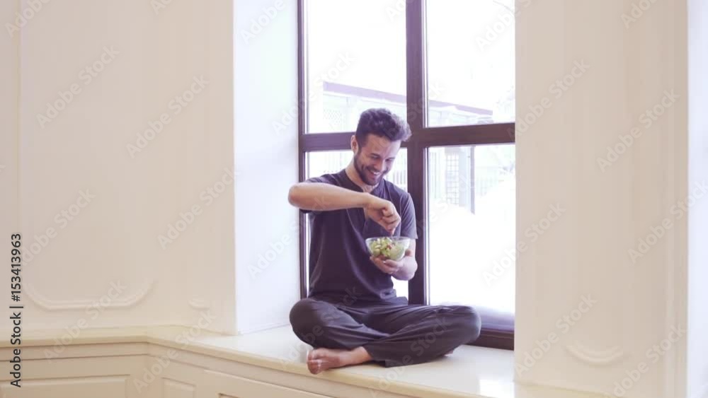 Yoga men with a bowl of vegetable salad, a bottle of water wearing a sportive outfit. Healthy lifestyle concept Yoga men with a bowl of vegetable salad, a bottle of water wearing a sportive outfit. Healthy lifestyle concept