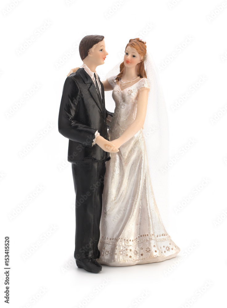 Figurines of a wedding cake on a white background, bride in a dress, bridegroom in a black tuxedo. Isolated Figurines of a wedding cake on a white background, bride in a dress, bridegroom in a black tuxedo. Isolated