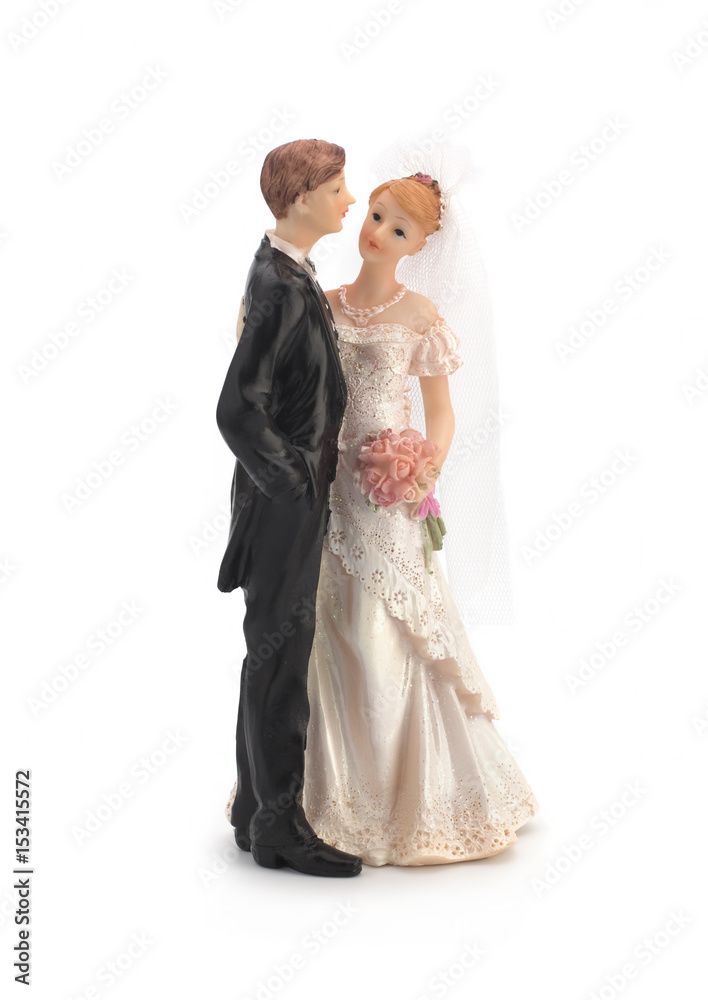 Figurines of a wedding cake on a white background, bride in a dress, bridegroom in a black tuxedo. Isolated Figurines of a wedding cake on a white background, bride in a dress, bridegroom in a black tuxedo. Isolated