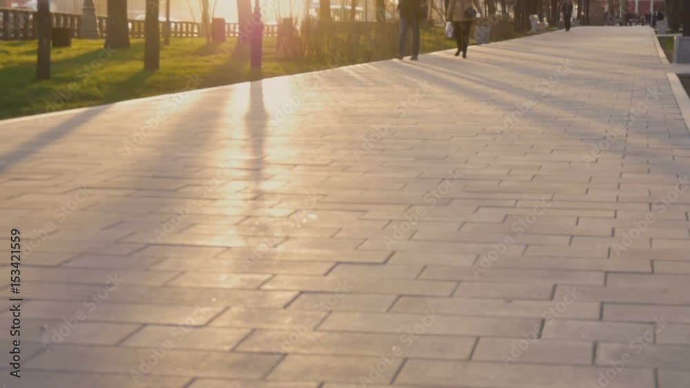 People go on a city street in sunset People go on a city street in sunset