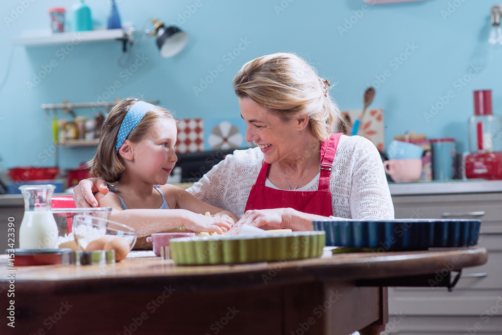 A mother and her daughter making pastry in a full color kitchen A mother and her daughter making pastry in a full color kitchen