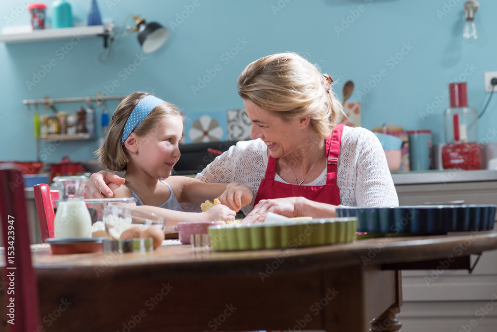 A mother and her daughter making pastry in a full color kitchen A mother and her daughter making pastry in a full color kitchen