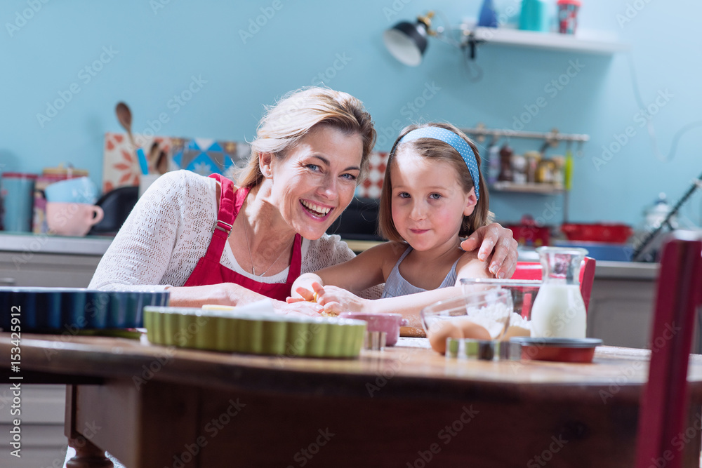 A mother and her daughter making pastry in a full color kitchen A mother and her daughter making pastry in a full color kitchen