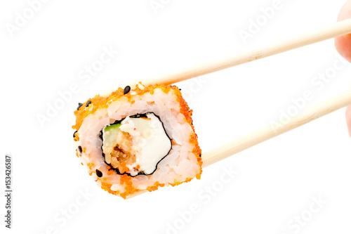 Holding sushi roll with chopsticks.