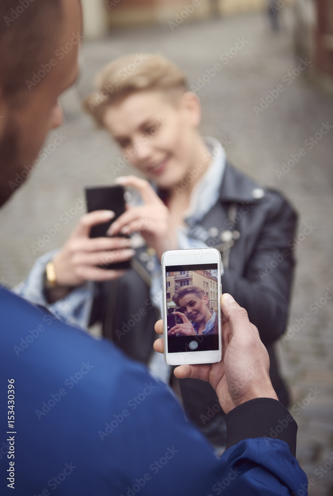 Rear view of man taking picture of his girlfriend