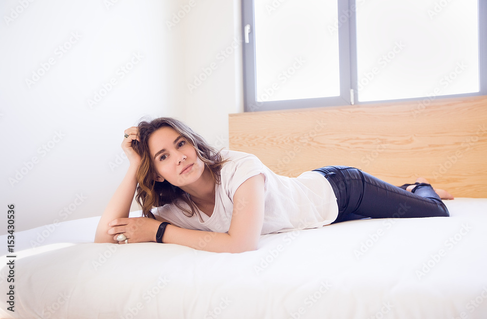 Beautiful woman lying on a couch.curly hair,pretty face,happy woman,woman in white t-shirt,woman at home,resting,attractive Beautiful woman lying on a couch.curly hair,pretty face,happy woman,woman in white t-shirt,woman at home,resting,attractive