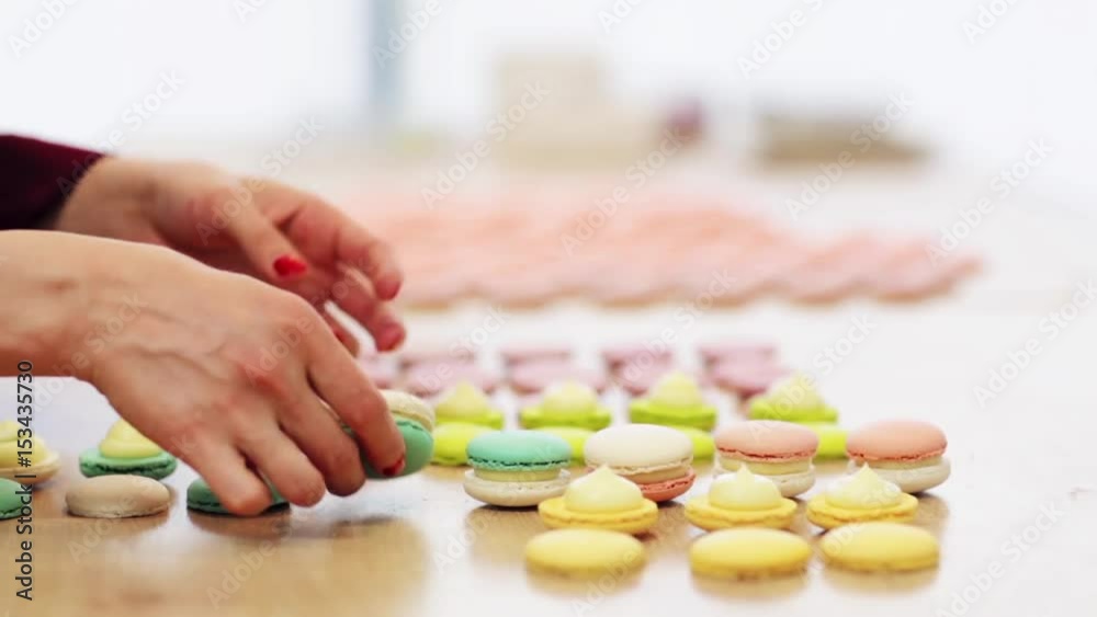 chef sandwiching macarons shells with cream chef sandwiching macarons shells with cream