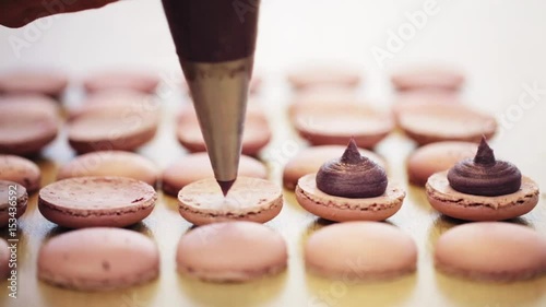 chef with injector squeezing filling to macarons