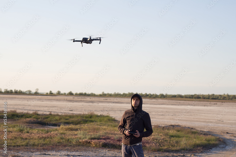 custom made wallpaper toronto digital picture of black flaying quadrocopter dron and pilot siluette in sunset light background, tourist use dron helicopter to photography or filming desert landscapes