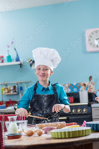 A little boy having fun while preparing a cake in a kitchen