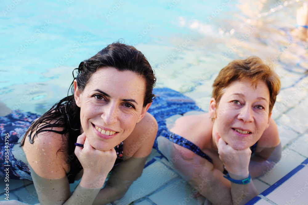 Portrait of two 40 years old women in swimming-pool