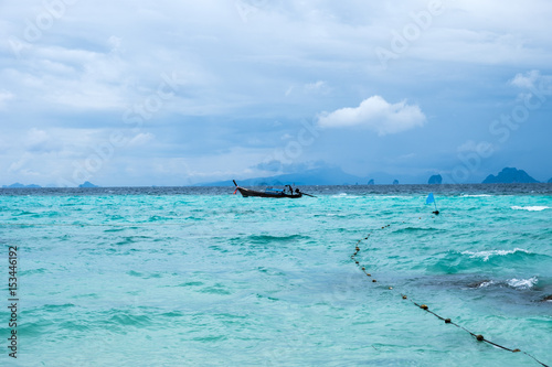 Wooden long tail boat on turquoise sea