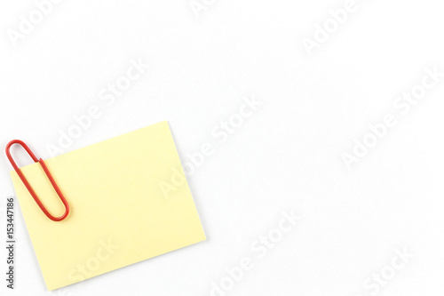 Yellow notepad with bracket on the corner and on the White table.Yellow note papers on White background.