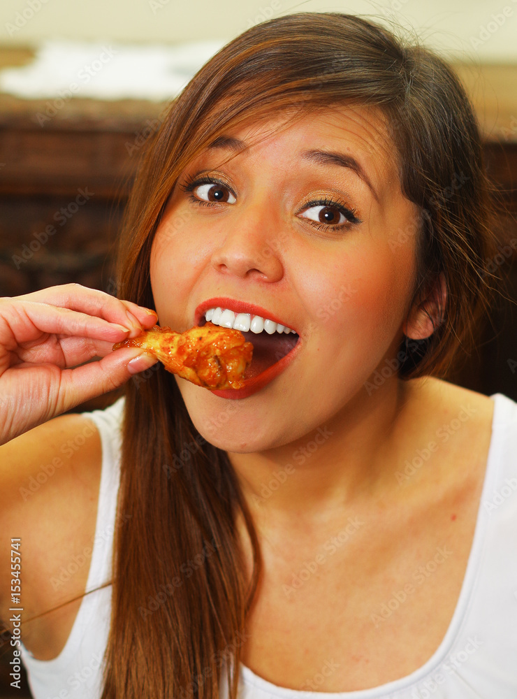 Close up of a beauty woman in a restaurant eating a delicious chicken wings Close up of a beauty woman in a restaurant eating a delicious chicken wings