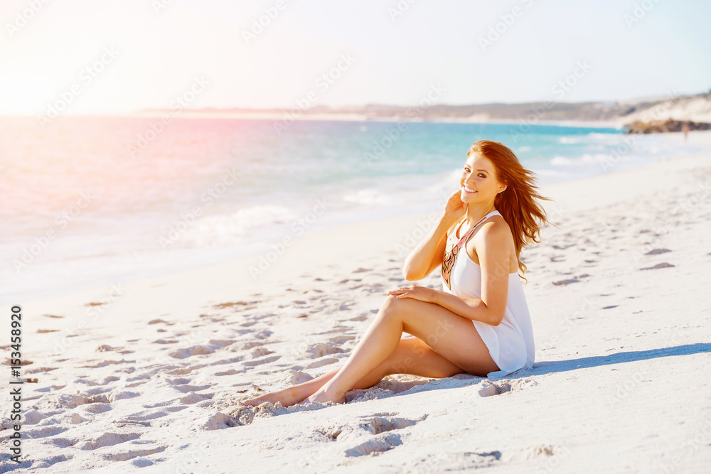 Young woman sitting on the beach
