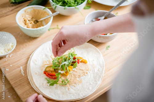 Wrap with zucchini, arugula, paprika, hummus and parmesan cheese