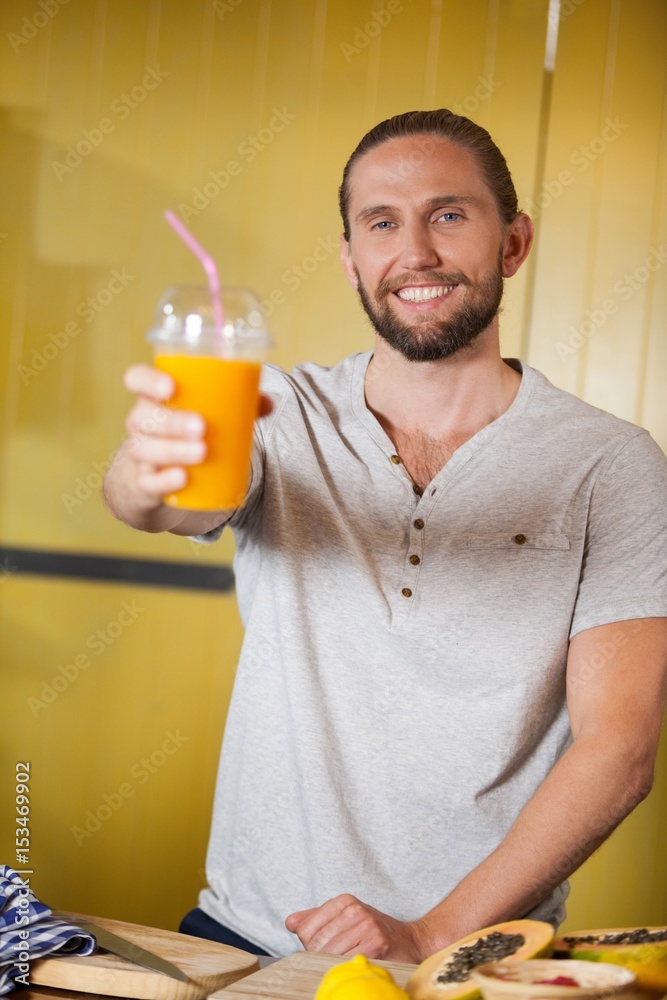 Male staff holding orange juice glass at organic section Male staff holding orange juice glass at organic section