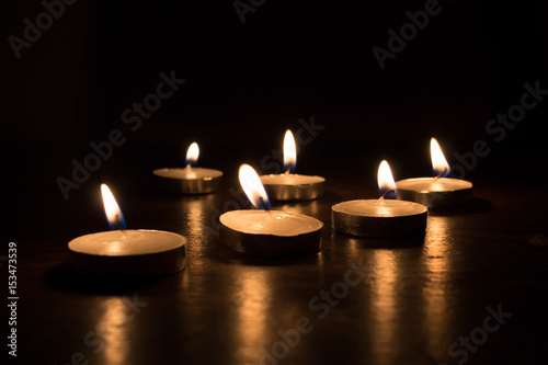 six small burning candles. Bright light on dark background. RIP darkness template. Birthday party. Romantic evening on Valentine.