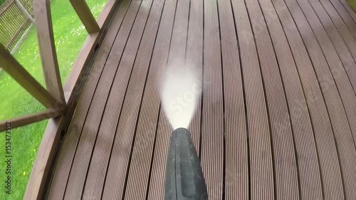 cleaning wooden terrace with high pressure washer photo