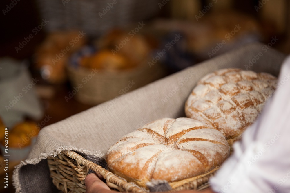 Hand of female staff holding basket of sweet foods