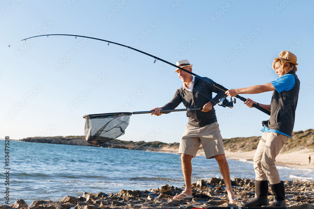 Senior man fishing with his grandson