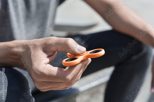 young man playing with a fidget spinner photo