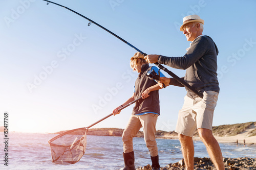 Senior man fishing with his grandson