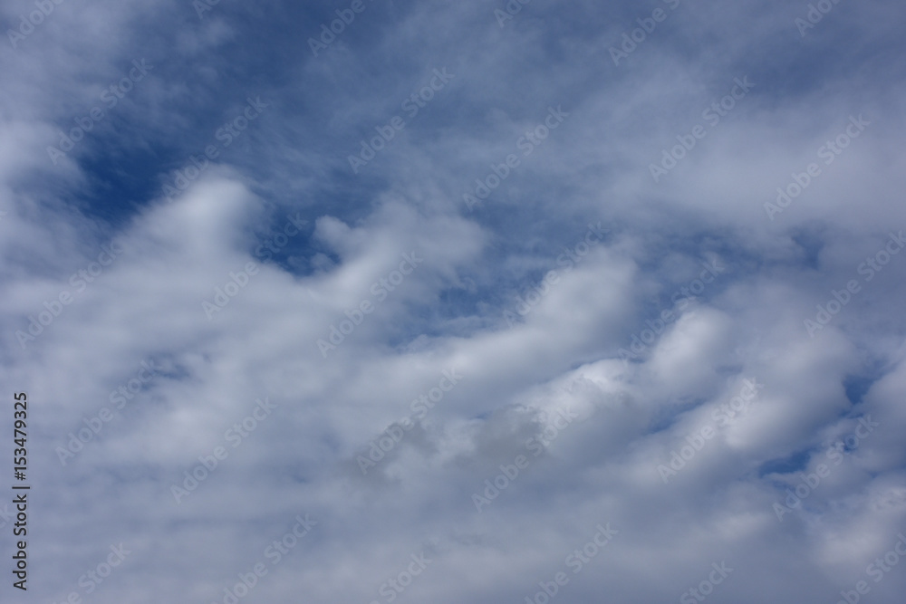 不思議な雲が並ぶ光景と青空「空想・雲のモンスターの誕生」整列、規則正しい、平等、並ぶなどのイメージ。下の雲などにタイトルスペース（案・「整列乗車！」「並んで！」など）