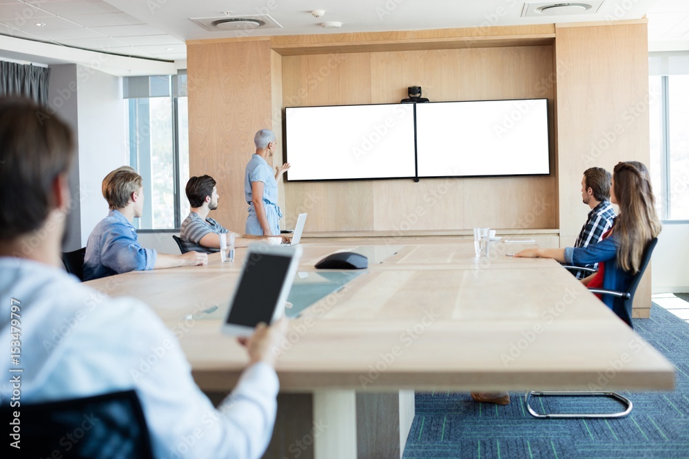 © WavebreakMediaMicro - Man holding a tablet while attending a meeting
