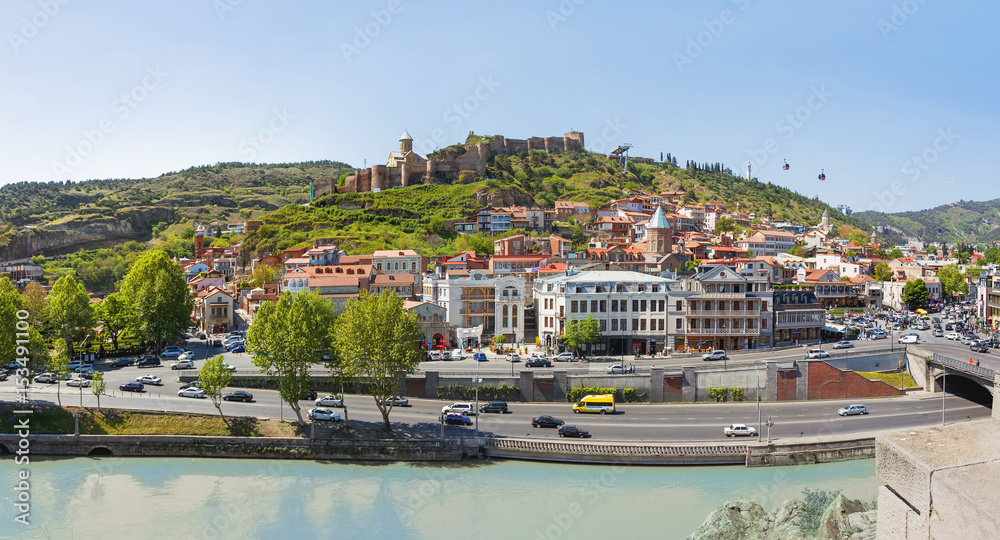 Panorama view of Tbilisi, capital of Georgia country. Landmarks - Narikala fortress, cable road above tiled roofs, Meidani square.