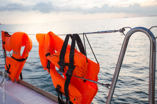 Life jacket hanging on a sea-side afternoon light boat.