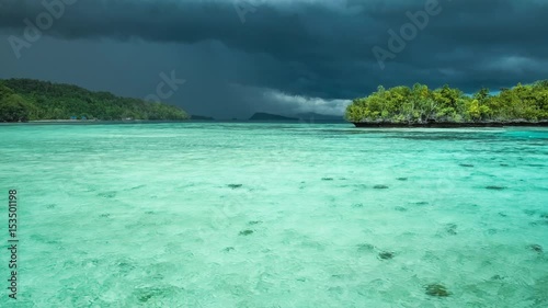 Beautiful blue lagoon with pure clear water shortly before thunderstorm begining, Gam Island, West Papua, Raja Ampat, Indonesia photo