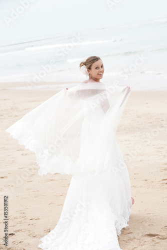 Bride walking on a sandy beach