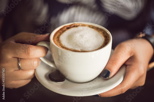 woman hands holding a cup of coffee