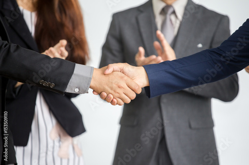 Businessmen hand shaking after striking grand deal with business team. photo